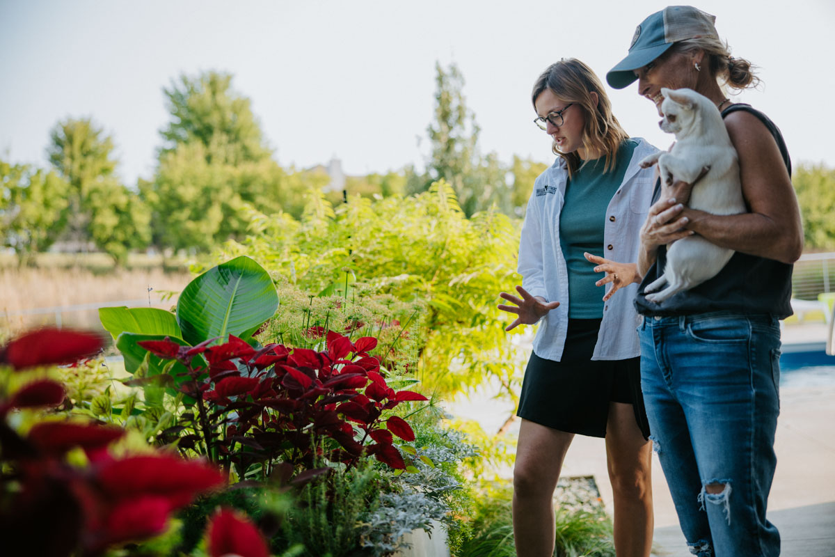 Weller Brothers lawn account manager talks with a client on her property