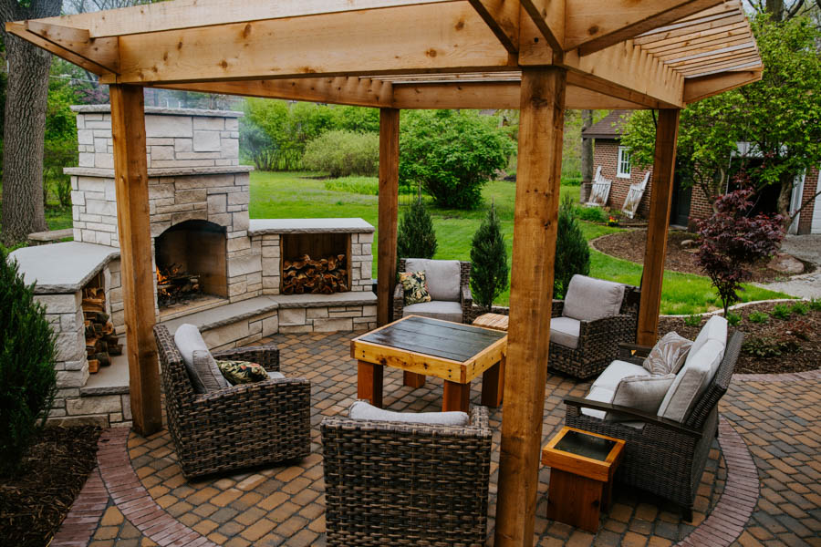 Custom patio area with mantel style fire place and pergola in Ames, IA