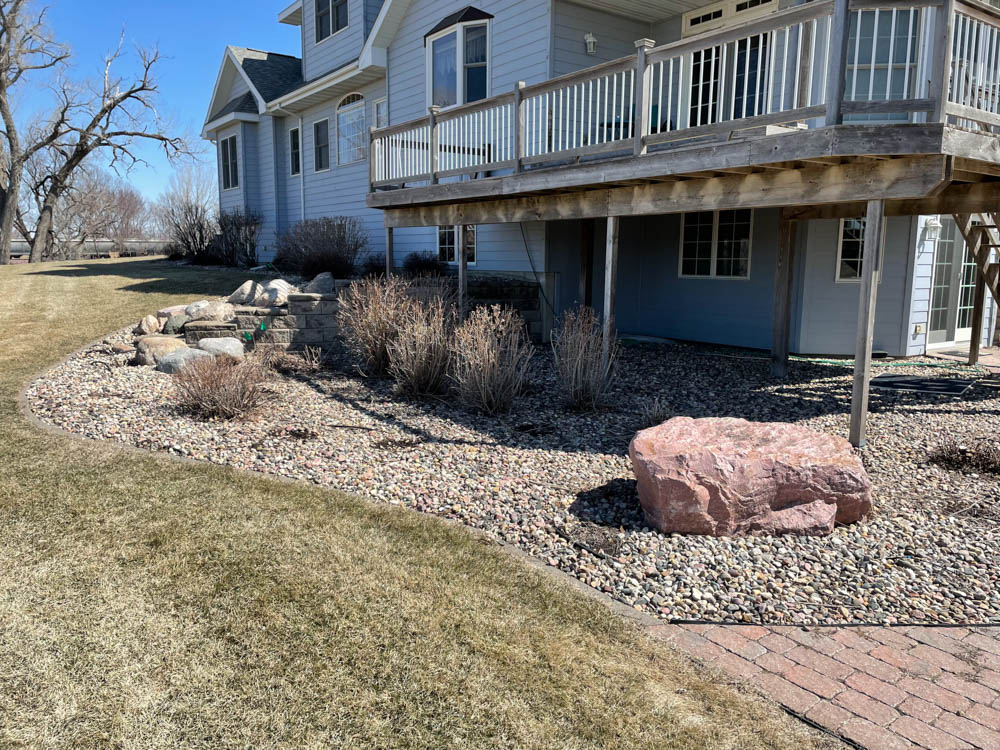 home with a rock bed and outdated landscaping