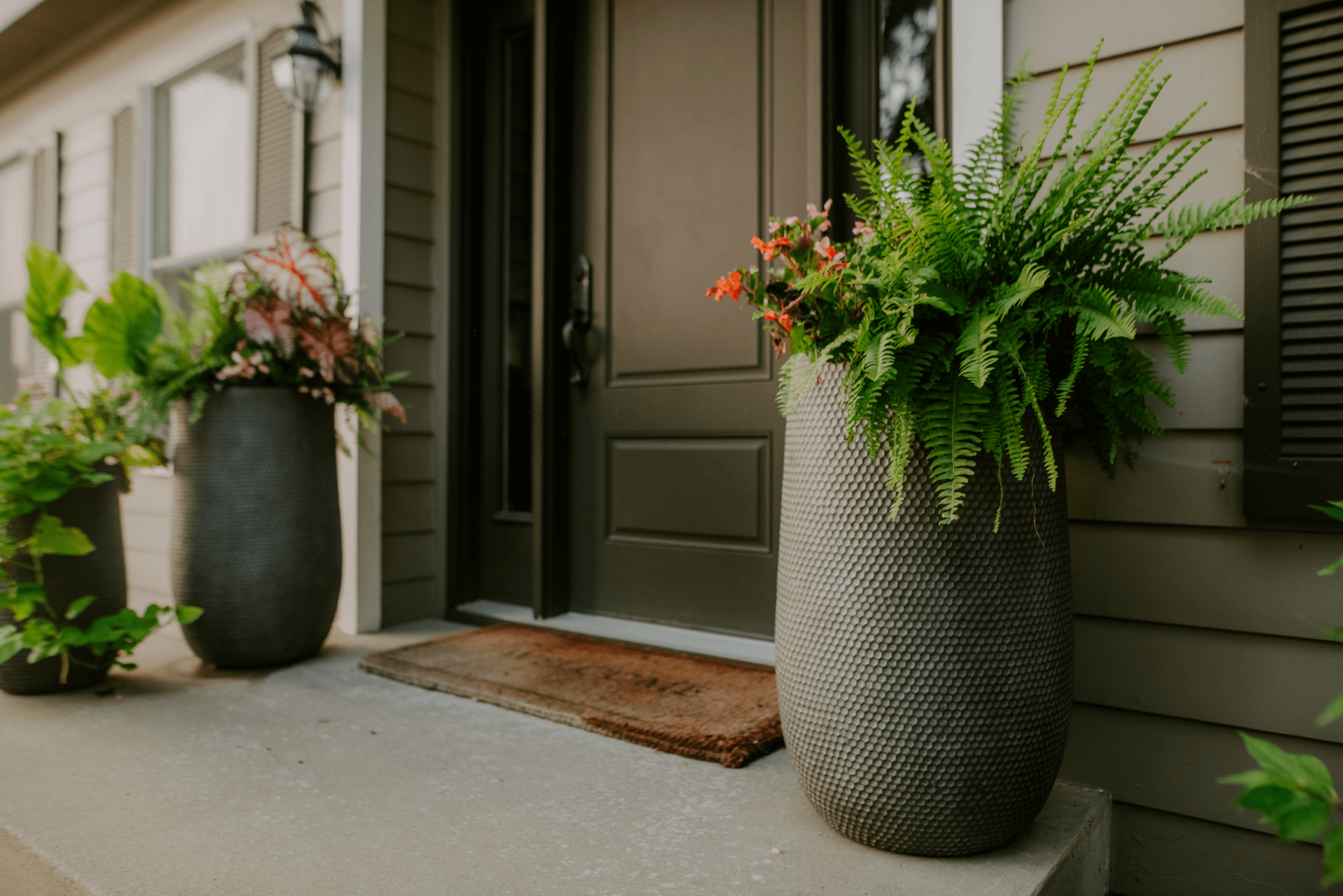 Large, gray flower pots on front porch of home