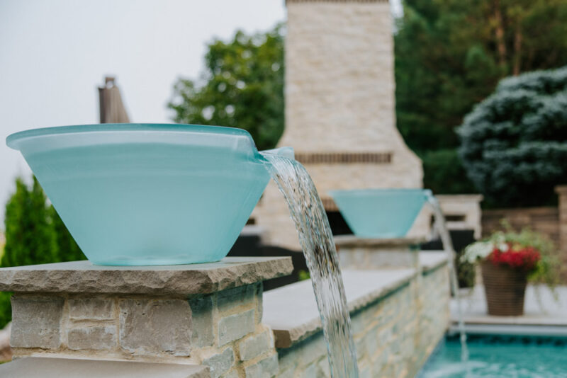 a close up image of water bowls alongside a pool