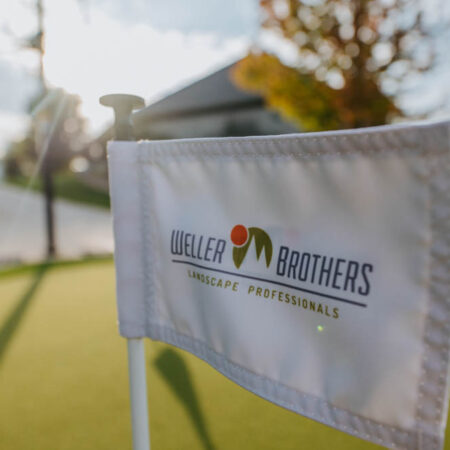 detail shot of a golf flag with the Weller Brothers Landscape Professionals logo