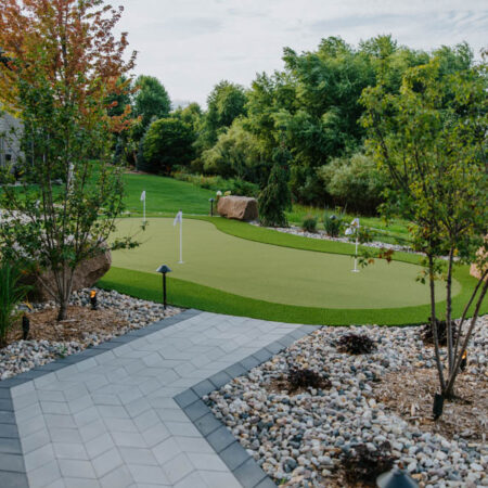 paver walkway approaches an artificial turf putting green