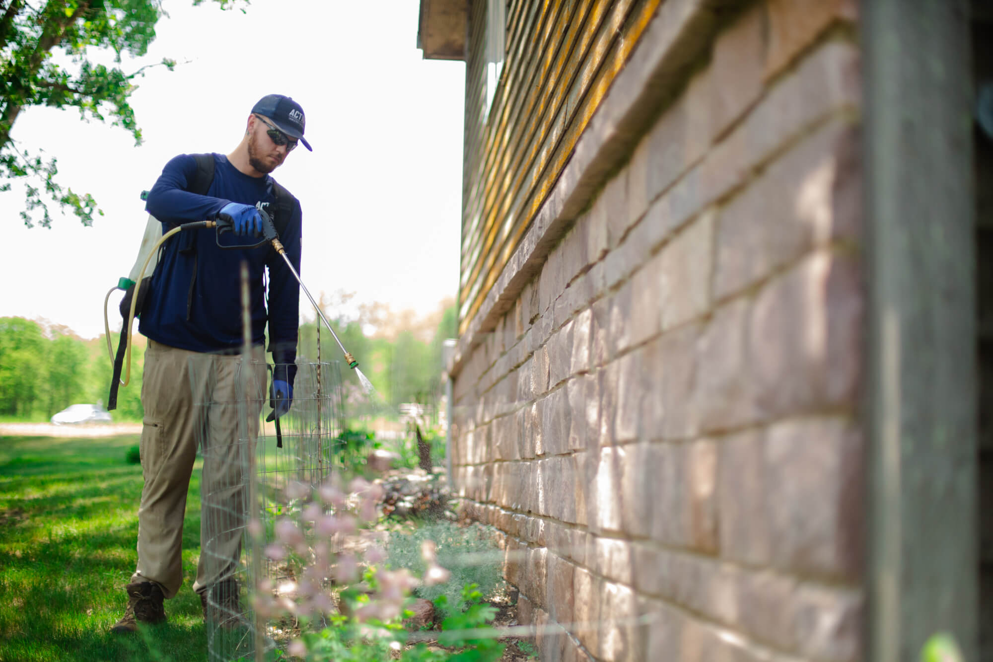 man applies perimeter pest control to a Sioux Falls home